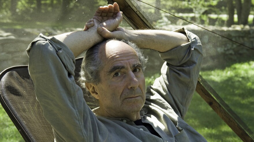 Famed novelist Philip Roth sits inside a screened tent at his home on Sept. 5, 2005, in Warren, Conn. Roth died on Tuesday. He was 85.