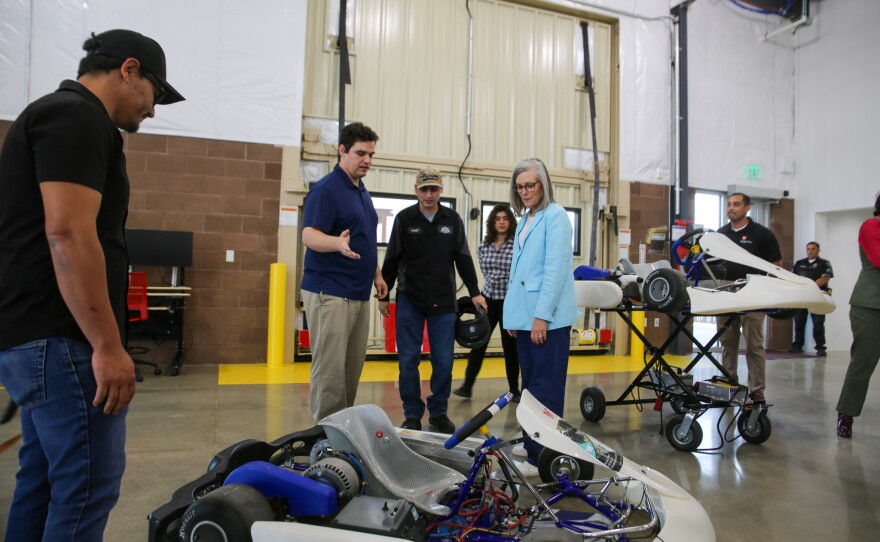 Students point to their electric go-kart which they use to learn about electric vehicle technology.