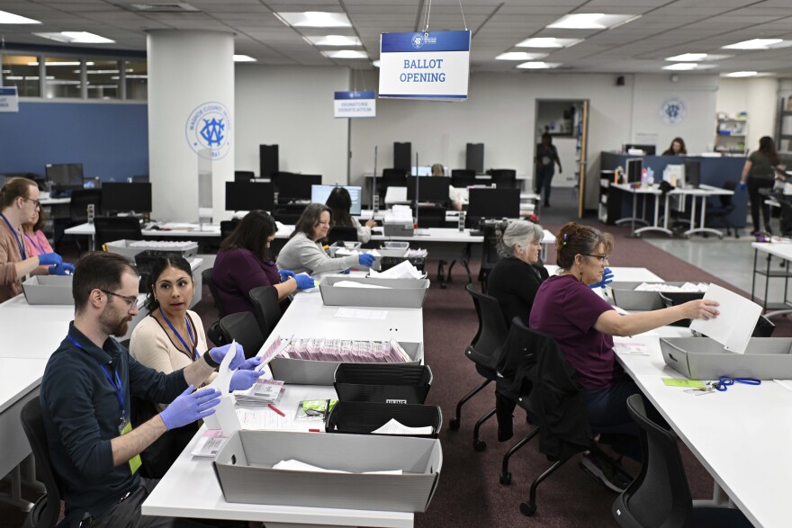 FILE - County employees open ballots in the ballot opening area of the mail ballot processing room at the Washoe County Registrar of Voters office in Reno, Nev. on Monday June 3, 2024 .Commissioners in Nevada’s second most populous county, Tuesday, July 9, 2024, refused to certify the results of two local recounts from last month’s primary, a rare move that has potential implications for the presidential race in one of the nation’s most important swing states.