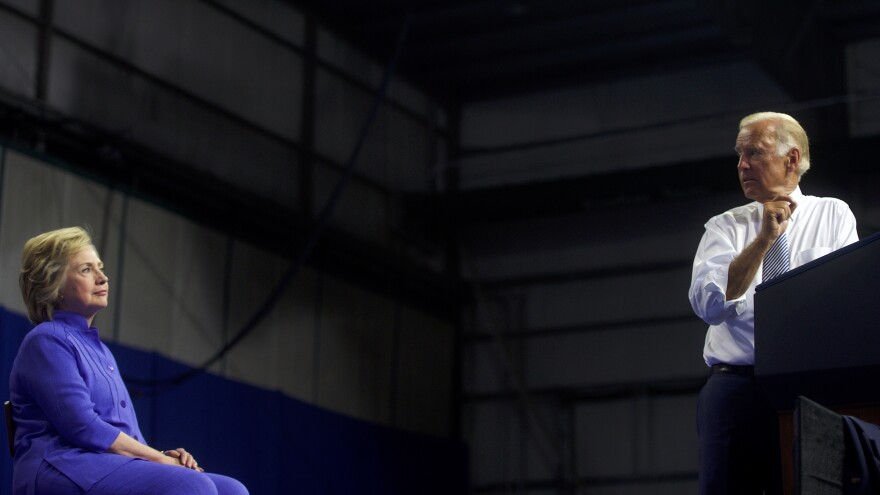 Joe Biden looks back at Hillary Clinton during a rally for Clinton in August 2016, three months before the presidential election. Biden writes in his new book he was very close to running himself.