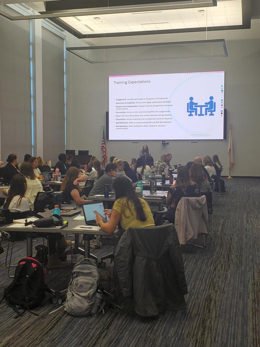 A lecture room filled with social workers and counselors with their computers taking training in EMDR