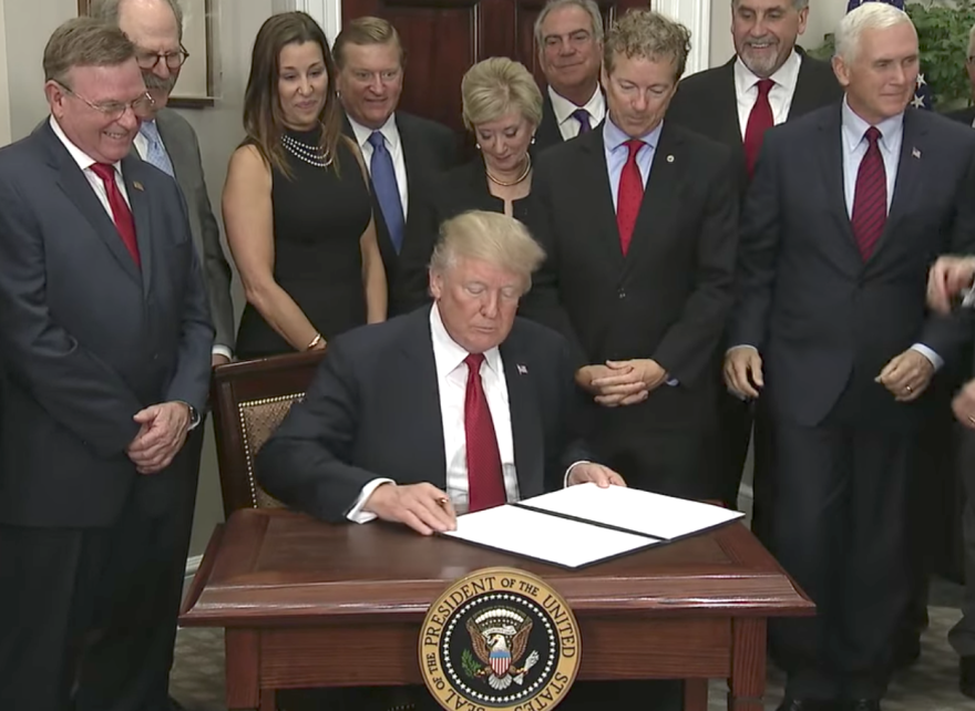 President Trump signs an executive order on Thursday. Dave Ratner of Dave's Soda and Pet City is second from left.