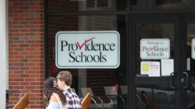 Students walk past a Providence Public Schools sign. The district continues to struggle with low reading and math scores as questions about its leadership emerge after seven years of state control. Credit: Ben Berke/Ocean State Media