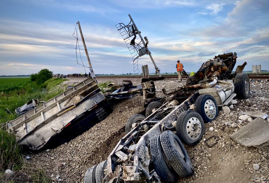 The truck destroyed in the Amtrak collision splayed across the steep railroad embankment