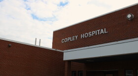 A photo of a brick exterior with silver lettering at its top reading copley hospital. 
