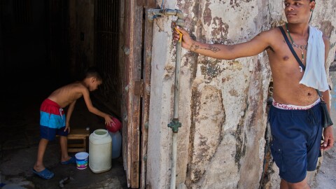 A youth collects water from the bottom floor of a residential building, during a blackout that stopped the water pump, in Havana, Cuba, Tuesday, July 14, 2026.