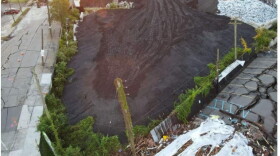 An aerial view of the ground shift, and the scrapyard experts believe caused it.