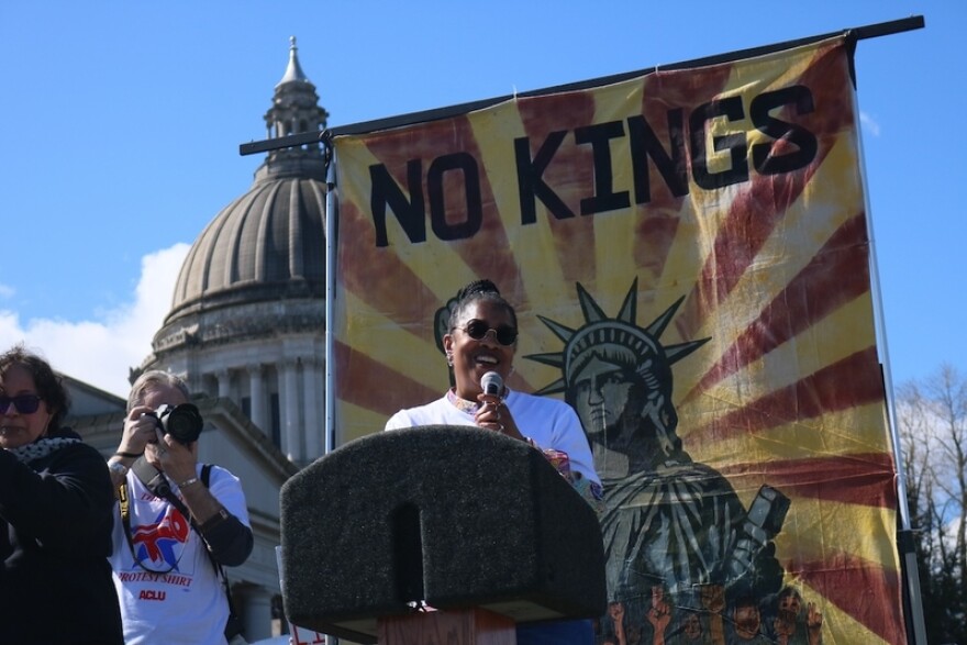 Michele Storms, executive director of the Washington state American Civil Liberties Union, speaks to a crowd during the No Kings protest in Olympia, Washington, on Saturday, March 28, 2026. (Photo by Aspen Ford/Washington State Standard)