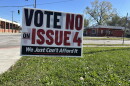 A yard sign on a corner in Evanston reads "Vot No on Issue 4. We just can't afford it."