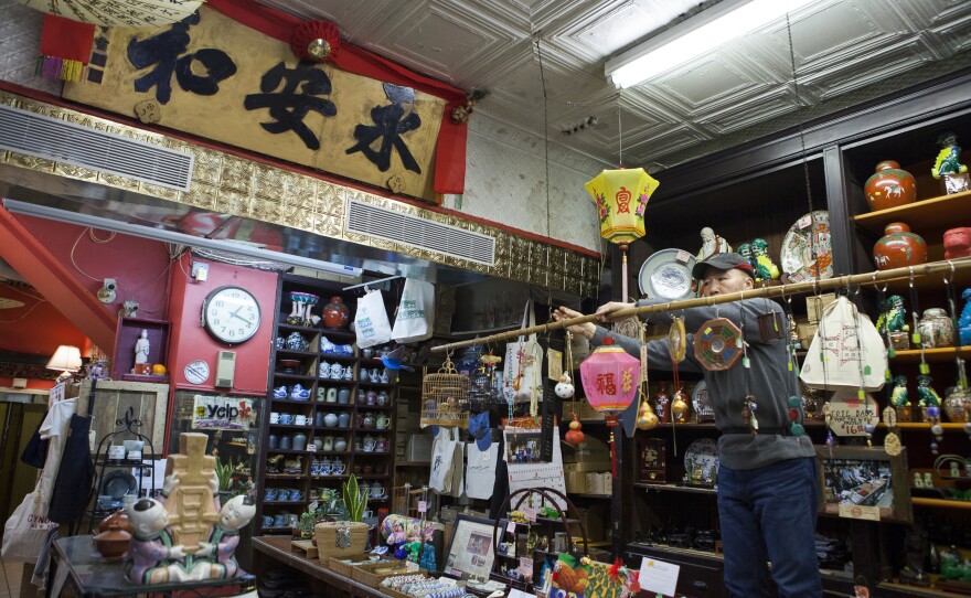 Mei's father, Gary Lum, adjusts new and antique items.