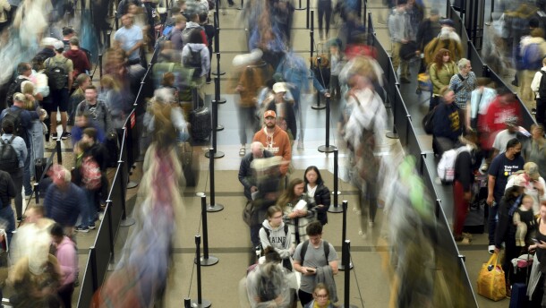 Travelers wait in a security line at Denver International Airport on Tuesday, Nov. 21, 2023, in Denver.