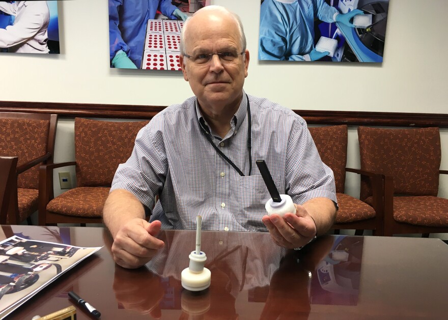 CDC's Dr. Jim Pirkle holds an e-cigarette attached to test base.
