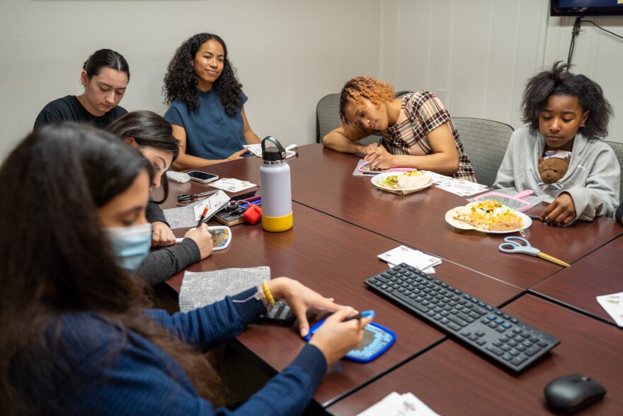 Group shot of students and clients writing on their mirrors 