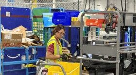 An unidentified employee at the Amazon delivery station in Yuma prepares an order.