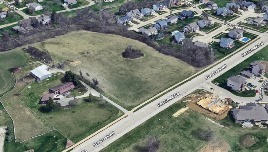 An aerial image from Google Earth shows a vacant 6.5-acre plot of land north of Fox Creek Road in Bloomington where a developer plans to build a subdivision with 58 single-family townhomes.