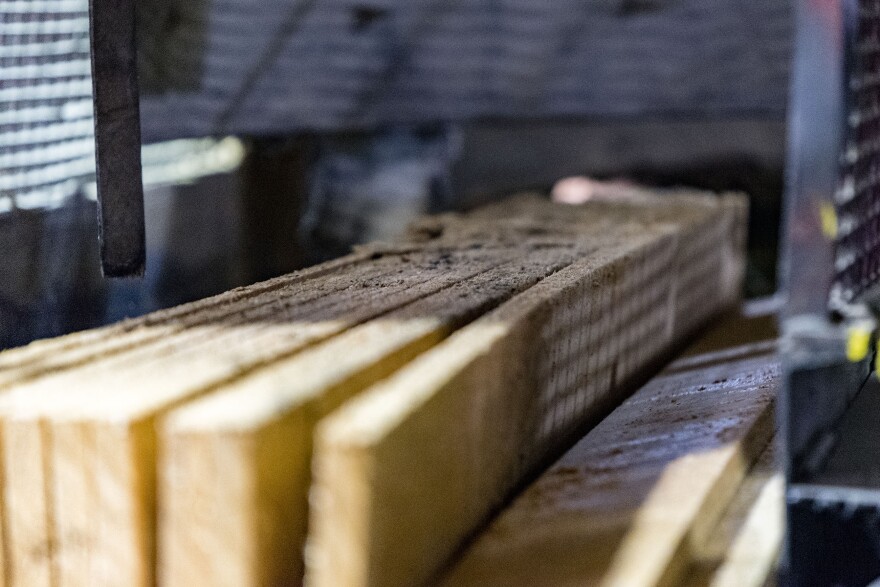 Boards come out of multi-bladed saw at the plant.