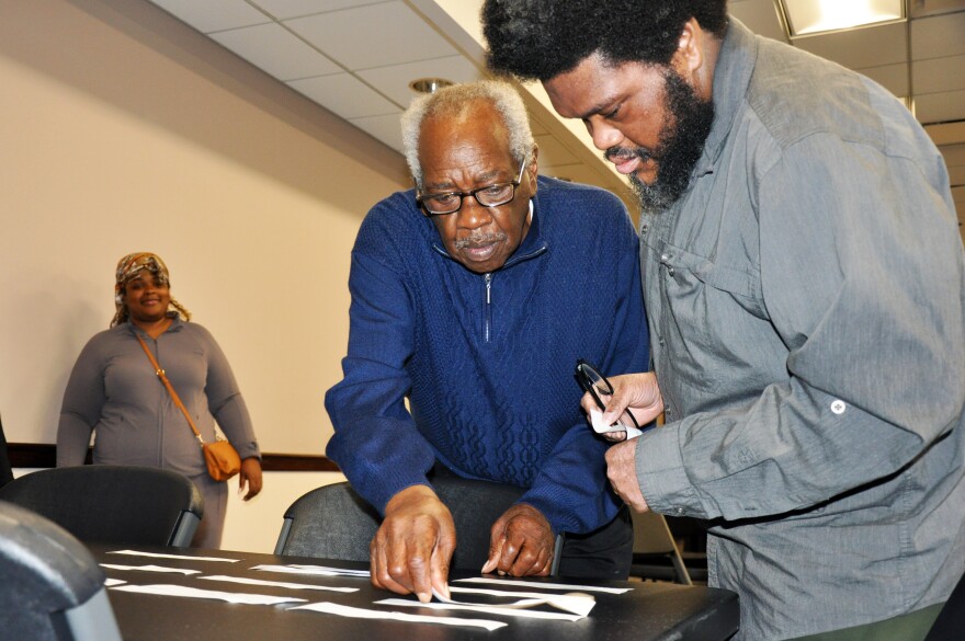Two men participating in the Beanstalk workshop match slips of paper representing precautions to emergency risks.
