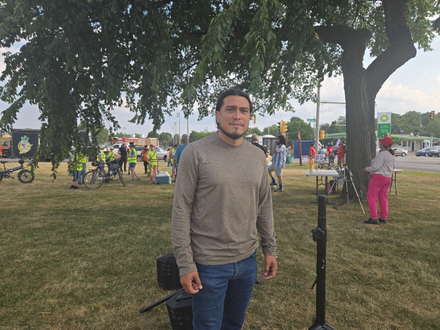 Alan Chavoya stands underneath a tree with other protesters nearby