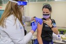 Truman Medical Center phramacist Sara Lauterwasser injects ICU nurse Sarah Kiehl on Monday afternoon with the first COVID-19 vaccine at Truman Medical Center.