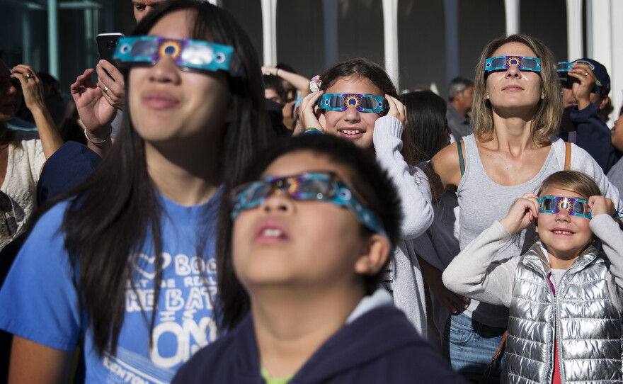 From left, Helen Le, Cadin Le, 10, Anastasia Wilcox, 12, Lesia Wilcox, and Anna Wilcox, 7, look toward the sun during the solar eclipse on Monday, August 21, 2017, at the Pacific Science Center in Seattle. KUOW Photo/Megan Farmer