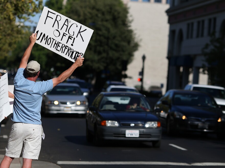 A protestor holds a sign against fracking during a demonstration outside of the California Environmental Protection Agency headquarters on July 25, 2012.