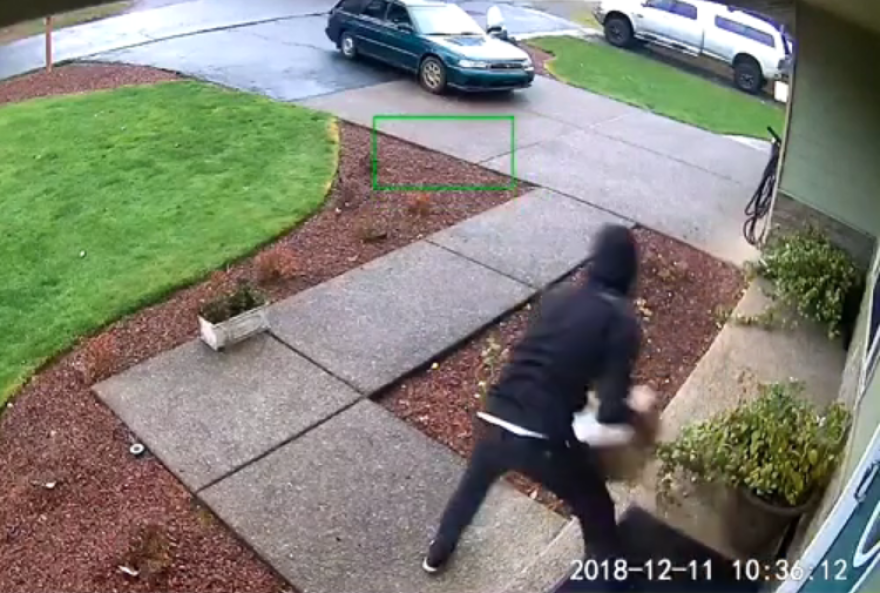 A porch thief makes a quick steal in this 2018 video still image shared by Oregon City Police.