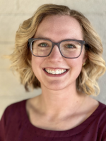Smiling woman with glasses and short blonde hair