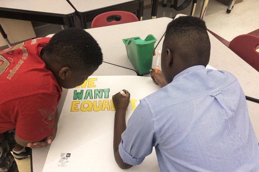 LaKevia Dismal's students work on posters illustrating the theme of the book the class is reading.