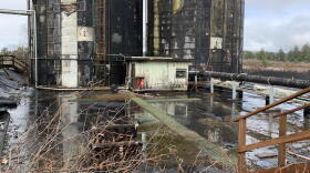 Two large, rusted towers on a waterlogged site. 