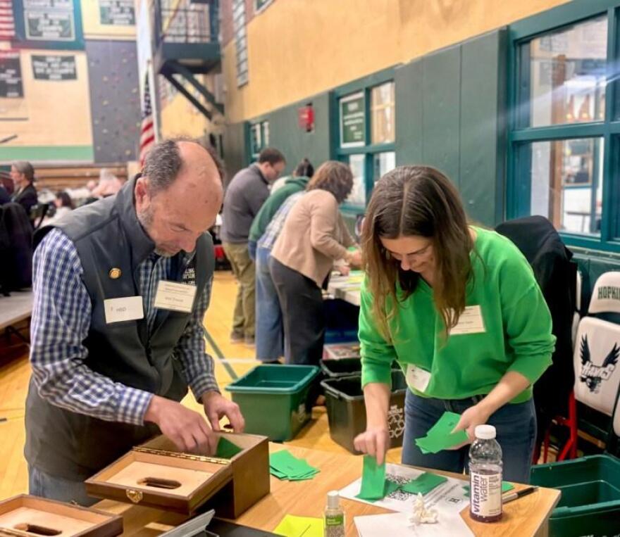 Ken Traum and Andrea Kane count the ballots cast for Hopkinton’s school district’s operating budget.