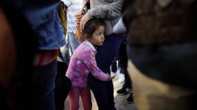 A Central American girl waits with her family at the U.S. border at Tijuana, Mexico, to request asylum.