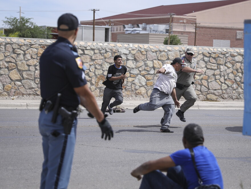  El Paso police and Texas Department of Public Safety officers chase a group of migrants in South Central El Paso on May 6. 