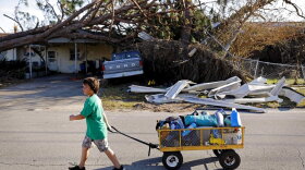 Anthony Weldon, 11, pulls a cart with his family's belongings as they relocate from their uninhabitable damaged home to stay at their landlord's place in the aftermath of Hurricane Michael in Springfield, Florida, Monday, Oct. 15. (AP Photo/David Goldman)