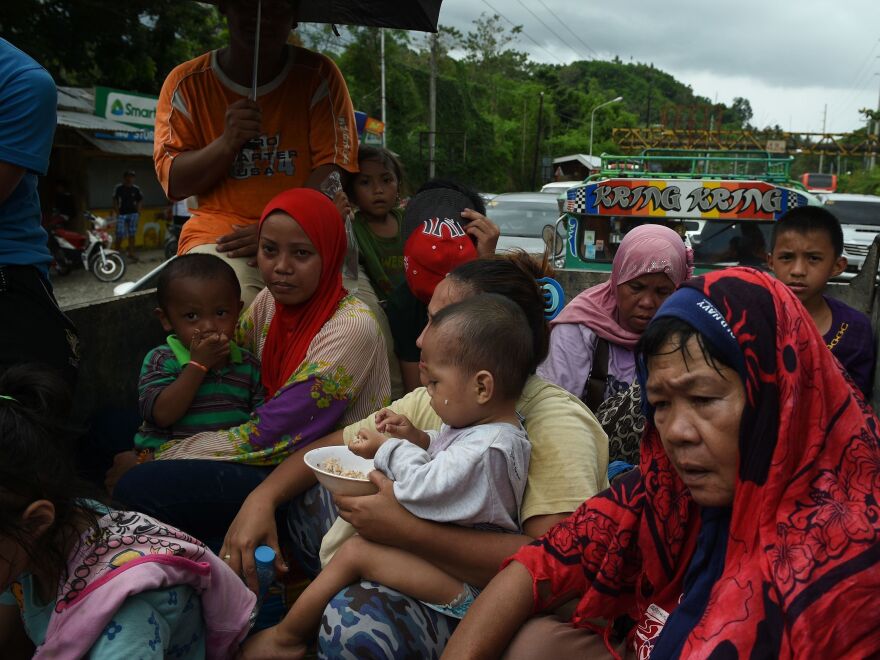 Residents fleeing Marawi City sit cramped in a truck that's stuck in gridlock near a police checkpoint at Iligan City, nearby on Mindanao.