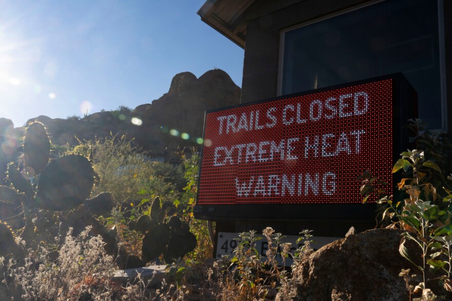 A sign warns hikers of trail closures due to extreme heat at Camelback Mountain on Thursday, March 19, 2026, in Phoenix.
