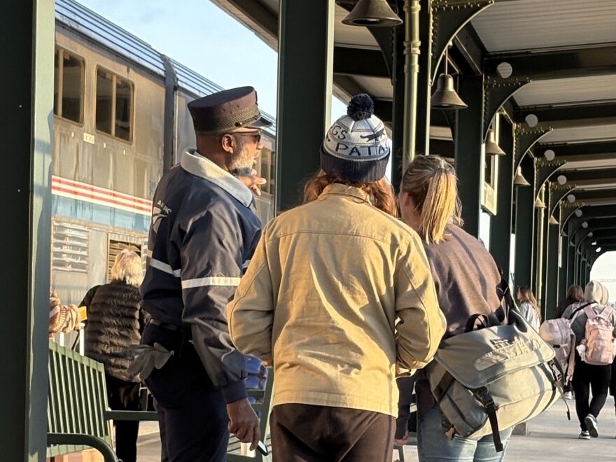 An Amtrak employee directs passengers to board the Heartland Flyer