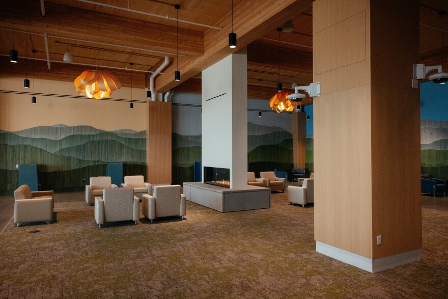 A seating area with a fireplace in the center and mountain motifs on the walls 