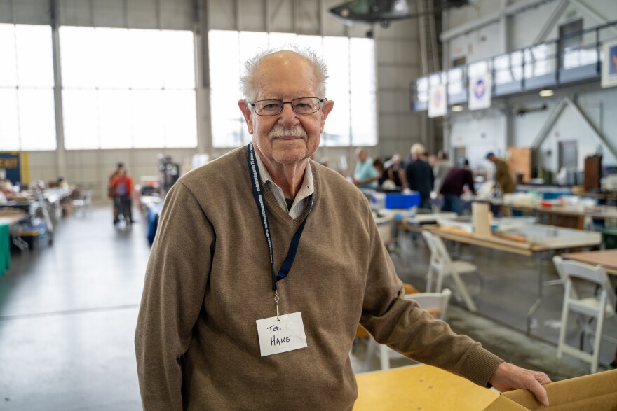 Man with glasses and a name tag around his neck that reads "Ted Hake"