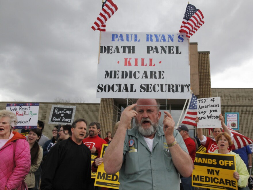Protesters in Kenosha, Wis., stand outside one of Ryan's listening sessions.