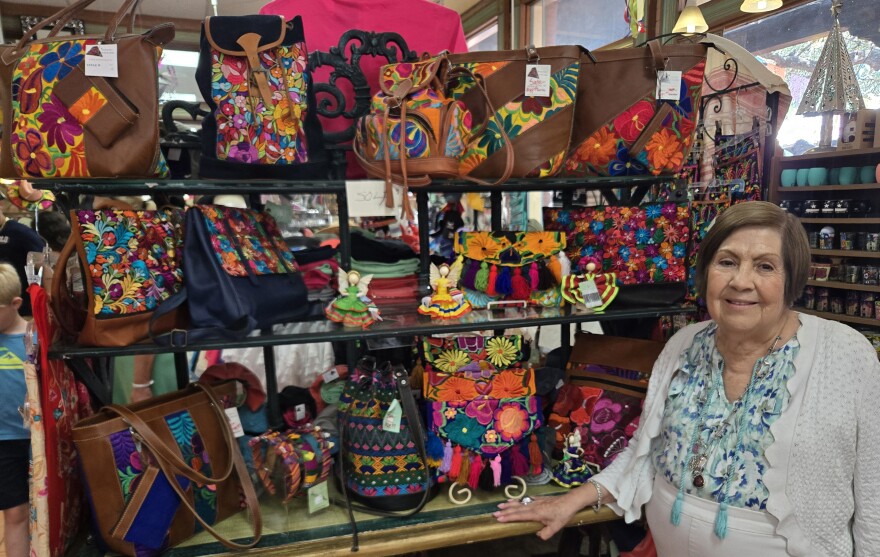 Edali Hernandez stands near rows of colorful purses and bagsold at her 3-story shop on July 27, 2026