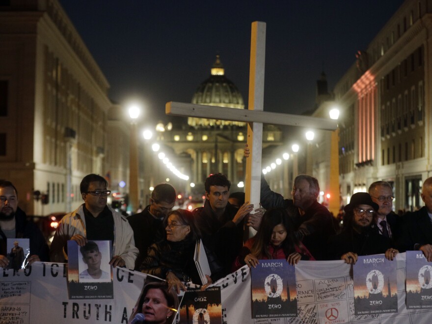 Survivors of sex abuse gather near St. Peter's Square during a twilight vigil in Rome on Thursday, the same day Pope Francis opened a landmark sex abuse prevention summit.