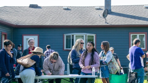 Several community members gathered around a folding table in a backyard to leave comments and concerns.