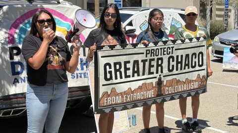 Executive Director for the Pueblo Action Alliance Julia Bernal (left) speaks through a megaphone alongside Alicia Gallegos, Leeona Goatson and Kira Padilla on July 29, 2026, outside the Bureau of Land Management’s Santa Fe office to protest.