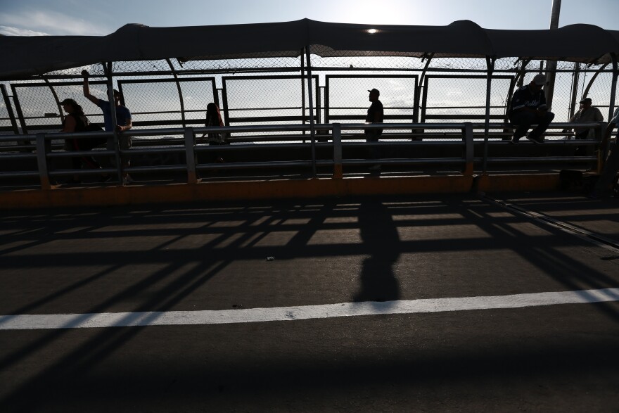 Pedestrians return to Ciudad Juarez, Mexico, as they cross the Paso del Norte bridge and leave El Paso, Texas, on Aug. 6, 2019. The Trump administration's policy forces asylum seekers to wait for their immigration court hearings in Mexico.