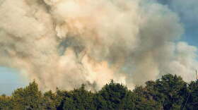 Smoke billows above the tree tops in Caddo County.