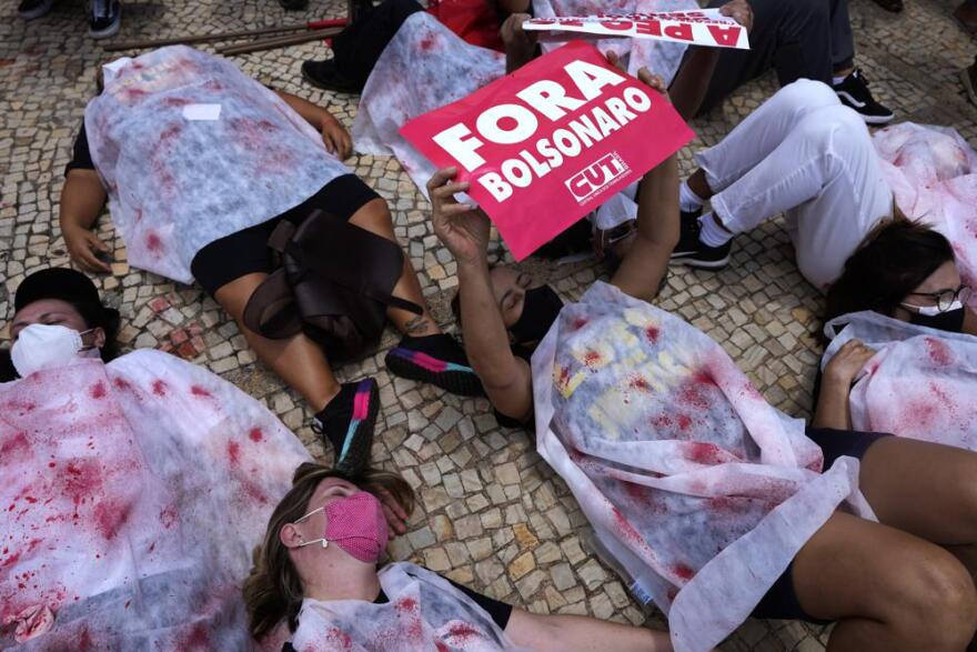 Protesters representing Brazil's more than 600,000 COVID dead demonstrate in Brasilia this week holding a sign that says in Portuguese "Bolsonaro Out"