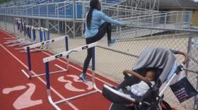 Dawn Harper-Nelson stretches during a training session at Belleville West High School as her daughter, Harper, naps nearby. 