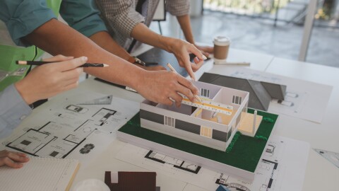 architects and engineers are discussing the design and structure of the upcoming building with the foreman to ensure that they understand the details on the same page, brainstorming, blueprint