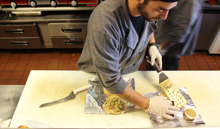 A worker at Moo Cluck Moo, a fast-casual burger and chicken chain in suburban Detroit, prepares a meal. Workers at Moo Cluck Moo all make $15 an hour.