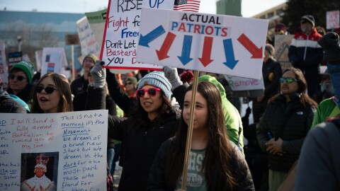 A mom and her two daughters participate in a protest. 